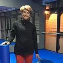Lucía-Carril muestra a una mujer con una camisa negra y pantalones rojos posando para una fot